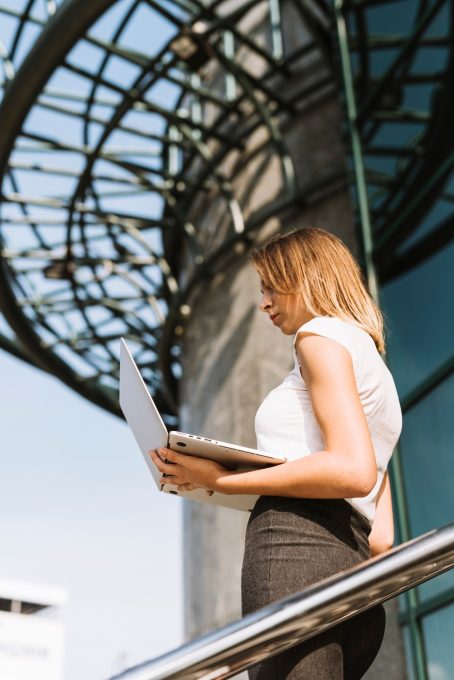 low-angle-view-blonde-young-businesswoman-looking-laptop_23-2147941645