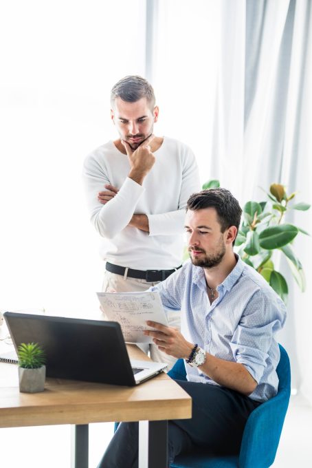 two-male-businessmen-working-office_23-2147839860