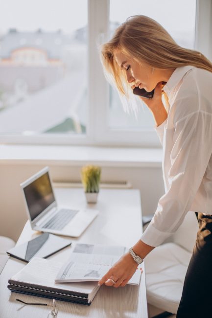 young-business-woman-using-phone-office_1303-26097